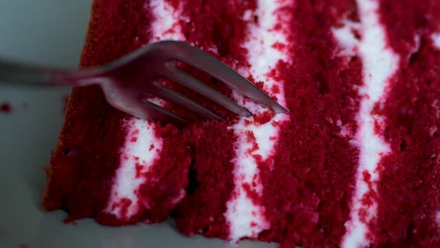 delicious cake red Velvet white airy cream red porous cake layers with fork crush dessert close-up. layers of cake layers of delicious cake pleasure and cooking culinary show study structure of dough
