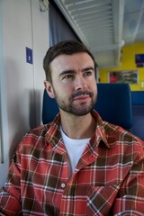 Obraz premium Handsome man sitting on train