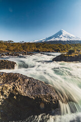 snow covered volcano by the river and waterfalls in puerto varas in chile