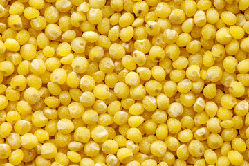 Millet groats, round yellow seeds, close-up, uniform texture background