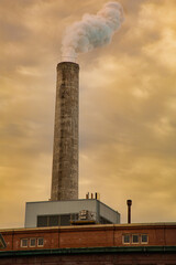 Toxic fumes from factory spew into an apocalyptic golden brown sky