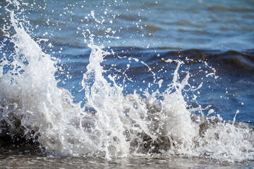 Fototapeta premium Splashes and white drops from the waves of the sea surf close-up, selective focus