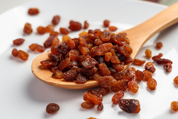 Dehydrated sweet sundried raisins in wooden spoon