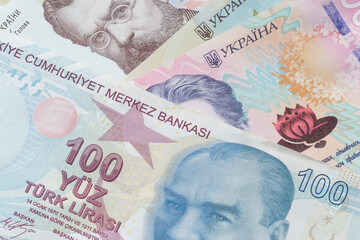 close up of one hundred Tukish lira banknote lying on Ukrainian hrivnya banknotes