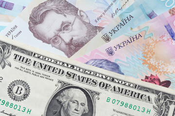 one United States dollar banknote lying on Ukrainian hrivnya banknotes