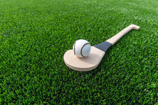 Hurling bat and sloitar on green grass. Horizontal sport theme poster, greeting cards, headers, website and app