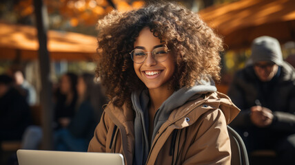 Obraz premium african american student girl making report with laptop , sitting at school building.