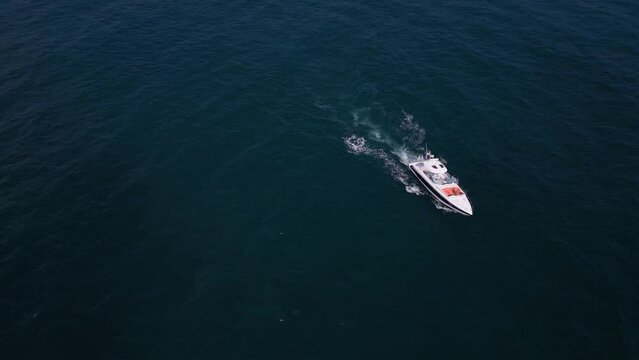 Aerial view of a pleasure boat racing through the sea waves, creating a mesmerizing picture of speed and freedom.