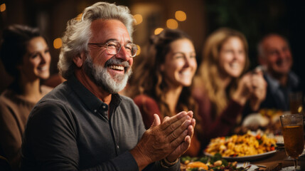 Happy Thanksgiving Day! Portrait of happy senior man clapping hands with friends during dinner party. - obrazy, fototapety, plakaty