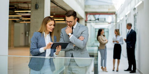 Business couple holding digital tablet and discussing company strategy - 652475566