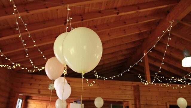 festive balloons against the background of holiday decorations. a group of white balloons filled with helium and tied into chairs. rustic wedding decor