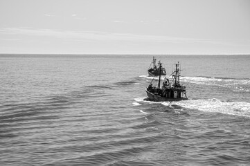 black and white image of two small Trawler fishing vessels, sailing in a calm Atlantic Ocean