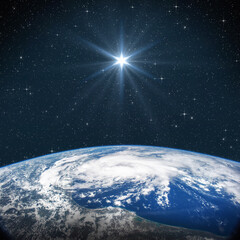 Bright star shines above the Earth in starry space. Birth of Jesus concept, Star of Bethlehem....