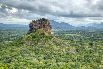 Ancient holy rock Sigiriya, green landscape with blue sky and clouds