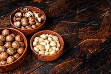 Unshelled Macadamia nuts ready to eat. Wooden background. Top view. Copy space
