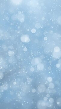 Beautiful blue blurred circle background with loop snowfall snowflakes vertical background.