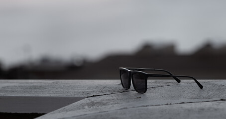 Fotografïa en blanco y negro de unas gafas de sol con fondo difuminado.