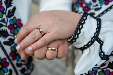 close-up view of a young couple holding hands in embroidered traditional Ukrainian clothes