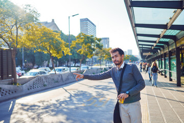 portrait young latin american commuter at the bus stop waiting for transportation