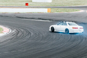  white racing car in a skid. drift, tire smoke. sports car at high speed. extreme sport.