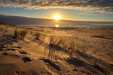 Beautiful sunset over the Baltic Sea in Poland. The setting sun in the sky and a beautiful sandy beach in Leba, Poland. - 652509769