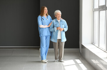 Female caregiver with senior woman in room