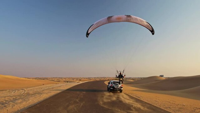 Following Close Behind Paraglider and Jeep On Desert Road - Dubai