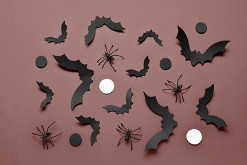 Paper bats and spiders for Halloween party on brown background