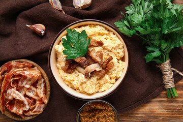 Bowl of tasty banosh and ingredients on wooden background