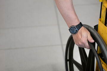 Close-up of the hand of a man who uses a wheelchair. Concept of reduced mobility. Image with copy spaces.
