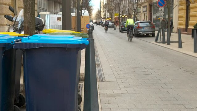 Garbage bins in public street with citizens. A view of garbage bins in the public road in the city in the day light. A concept of eco monement and clean streets.