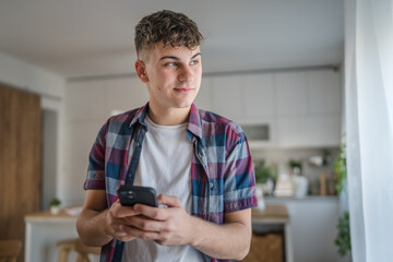 Obraz na płótnie Canvas One man caucasian male teenager boy use mobile phone smartphone sms