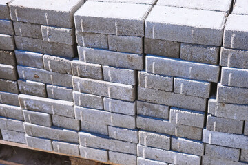 Gray sand-lime brick. New bricks for laying sidewalk lie in stacks on pallet. Background.