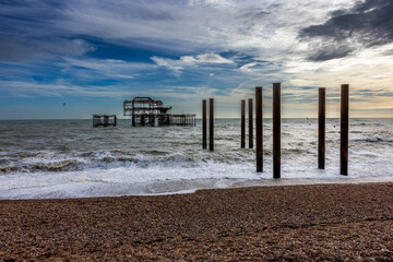 Burnt Brighton West Pier, at sunset. The Pier was built in 1866 and burnt down to its iron remains in 2003. Rusty iron columns stand as former connection to the shore. The destroyed pier is a landmark