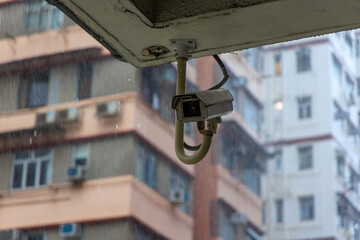 Security surveillance camera on high-rise apartment building in rain - 652541393