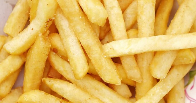 4K footage Close-up Rotating Loop spin top view French Fries or Chips , food texture background.
