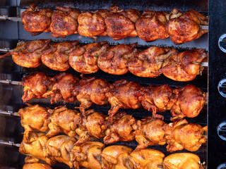 Savor the aroma of traditional rotisserie-roasted chickens, cooked to perfection, at Oktoberfest in Munich, a delectable treat cherished by festivalgoers