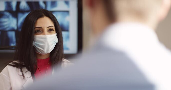 Consulting doctor, woman and covid face mask in hospital, medical healthcare, medicine worker, employee or insurance help people talking in checkup