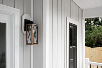 Southern Rustic Farmhouse Front Porch Light Sconce Next To Front Door and Grey Siding