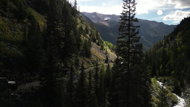 Aerial of jeeps four wheeling on Lead King Basin shelf dirt road in Marble Colorado in fall
