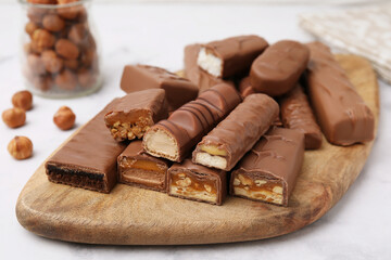 Pieces of different tasty chocolate bars on white table