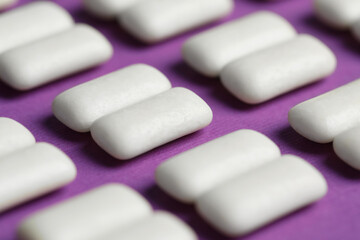 Obraz na płótnie Canvas Tasty white bubble gums on purple background, closeup