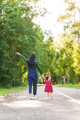 Fototapeta na wymiar Asian mom and daughter enjoying nature in park outdoor with sunlight, heartwarming bond, family time, mothers day concept, joyful family day, mother day picnic, thai ethnicity