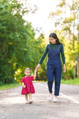 Asian mom and daughter enjoying nature in park outdoor with sunlight, heartwarming bond, family time, mothers day concept, joyful family day, mother day picnic, thai ethnicity