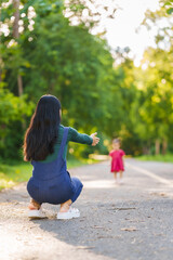 Asian mom and daughter enjoying nature in park outdoor with sunlight, heartwarming bond, family time, mothers day concept, joyful family day, mother day picnic, thai ethnicity
