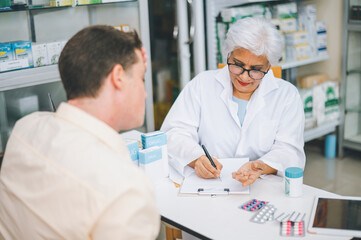 Obraz premium Pharmacist giving advice And advice for patients who come to buy Medicine, Drugs, Vitamins products, according to prescriptions in modern pharmacies.