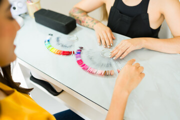 Hispanic client looking at the nail colors before her manicure