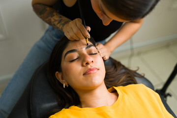 Top view of a client in the beauty salon doing her eyebrows