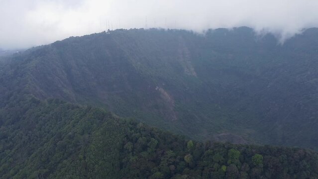 Misty cloud flyover: Rim of massive San Salvador volcano crater