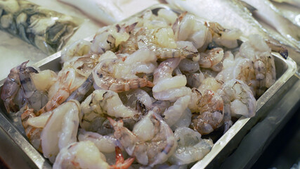 resh de-shelled shrimp meat in a iron plate. peeled-off raw material for cooking.
